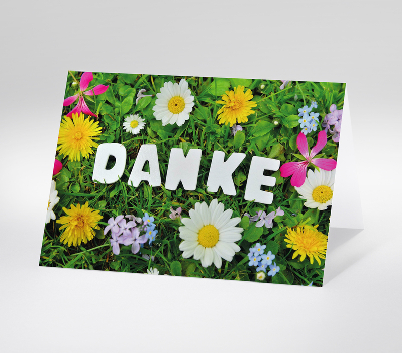 Dankeskarte mit Schriftzug DANKE auf einer bunten Blumenwiese  