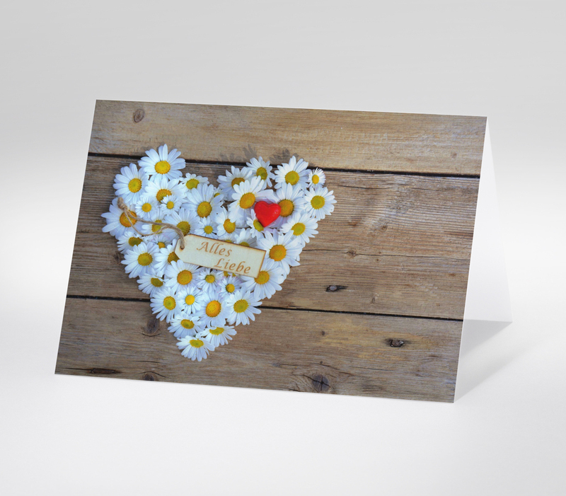 Herz aus weißen Gänseblümchen mit rotem Herz und Holzschild Alles Liebe auf Holzhintergrund