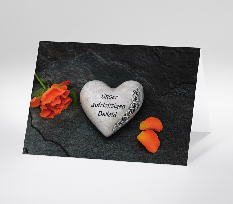 Trauerkarte mit grauem Herz aus Stein, Text Unser aufrichtiges Beileid und orangefarbener Rose