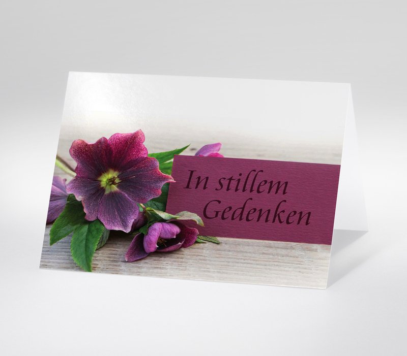 Lila Blume mit Karte In stillem Gedenken auf hellem Holzhintergrund