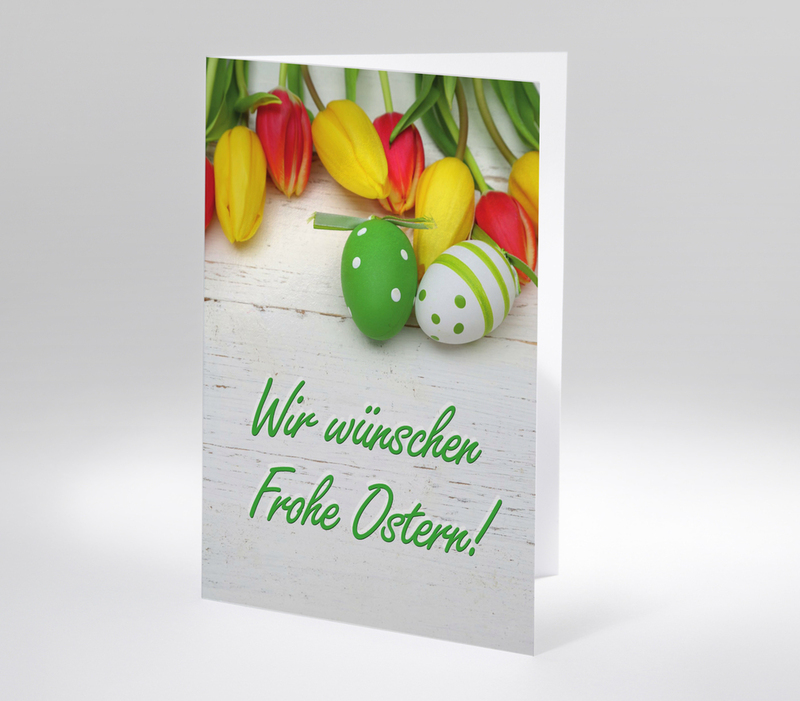 Bunte Tulpen mit zwei verzierten Ostereiern und Ostergruß Wir wünschen Frohe Ostern