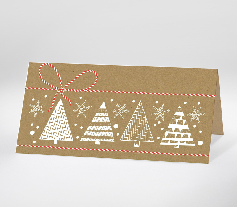 Minimalistische Weihnachtskarte mit weißen Tannen und Schneeflocken auf Kraftpapier mit rotem Band