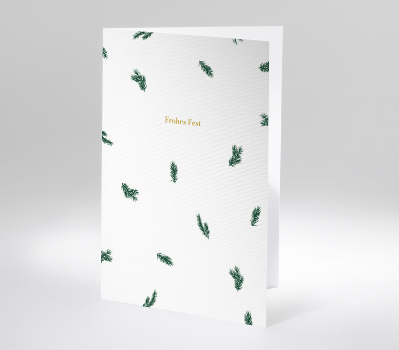 Schlichte Karte mit verstreuten Tannenzweigen und goldener Schrift Frohes Fest