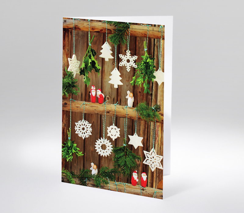 Rustikale Dekoration mit Holzleiter, Tannengrün und weißen Weihnachtsanhängern aus Keramik