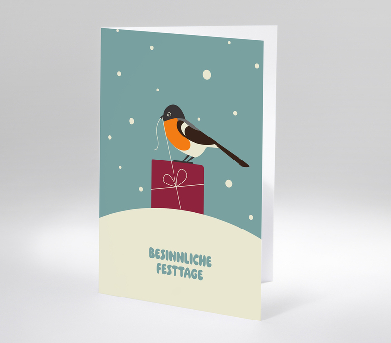 Weihnachtskarte mit Vogel auf Geschenkpaket und Schriftzug Besinnliche Festtage auf schneebedecktem Hügel