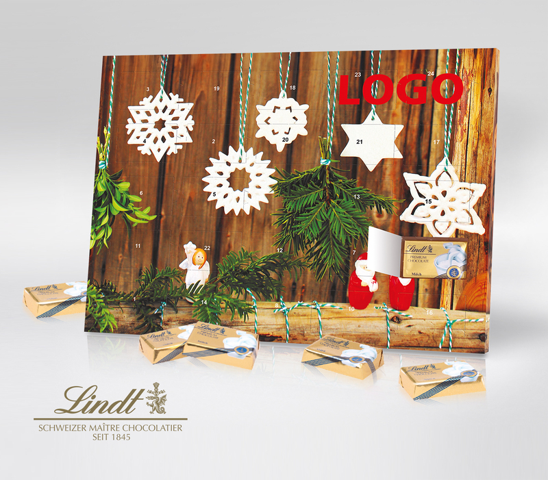 Tisch-Adventskalender von Lindt mit rustikaler Dekoration aus Holzleiter, Tannengrün und weißen Weihnachtsanhängern aus Keramik. zudem sind zwei rote Weihnachtsmänner und ein weißer Engel abgebildet.