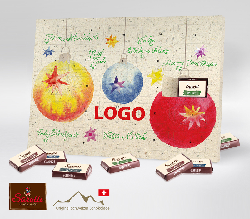 Tisch-Adventskalender von Sarotti aus Graspapier mit drei großen mit bunten Weihnachtskugeln und dem grünen Schriftzug Frohe Weihnachten in verschiedenen Sprachen.