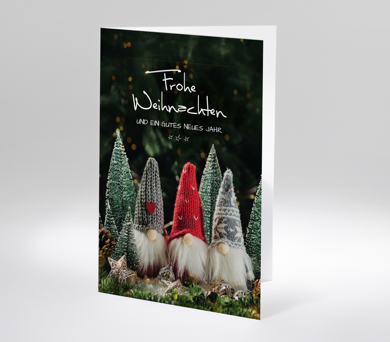 Weihnachtskarte mit drei Wichteln in Strickmützen und Tannenbäumen, roter Hintergrund, Text Frohe Weihnachten und ein gutes neues Jahr