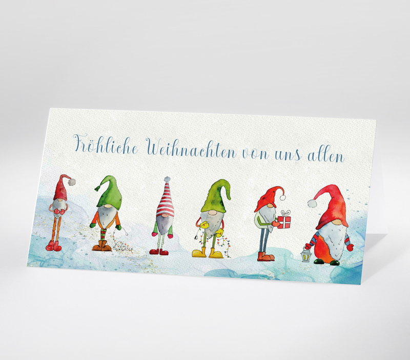 Aquarellzeichnung von sechs Weihnachtswichteln mit unterschiedlichen Mützen und Schriftzug Fröhliche Weihnachten von uns allen