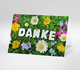 Dankeskarte mit Schriftzug DANKE auf einer bunten Blumenwiese  