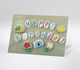 Bemalte Steine am Strand mit der Aufschrift Happy Birthday und bunten Motiven